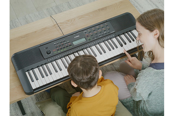Parent and child happily playing the PSR-E283 side by side
