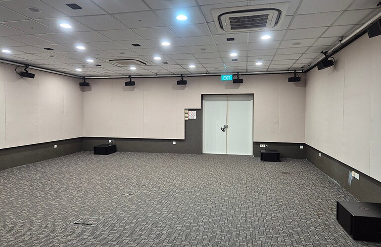 Singapore training facility room with seating, presentation screen, and audio equipment.