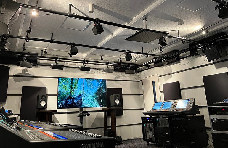 Yokohama training facility with a large display, digital mixing consoles, loudspeakers, and audio equipment.
