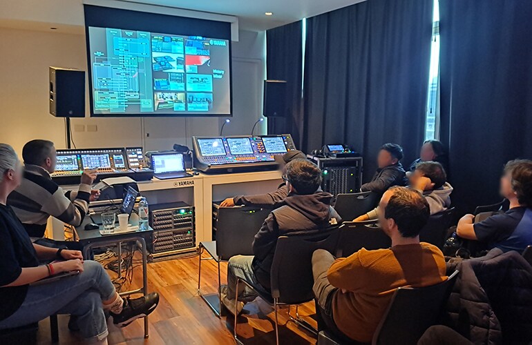 Buenos Aires training facility with attendees seated in an audio training room with projection and mixing equipment.