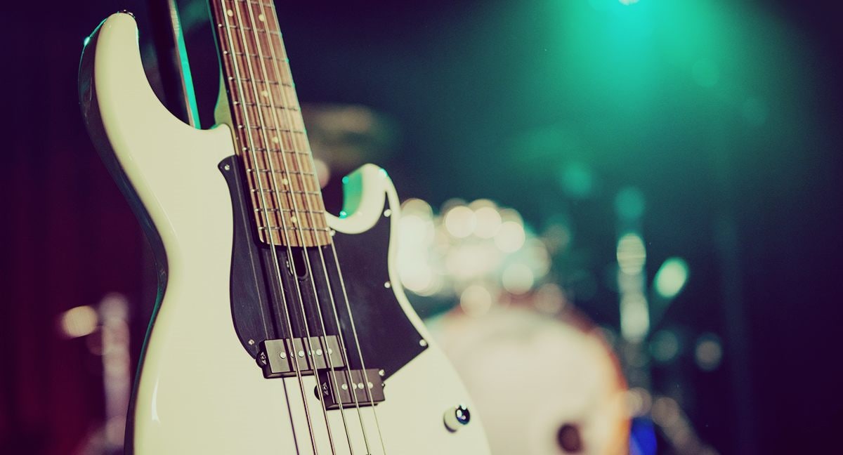 Closeup of BB235 Vintage White with soft focus on drumkit in the background